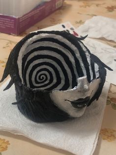 a black and white mask on top of a napkin