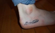 a person with a tattoo on their foot has a wrench drawn on the bottom