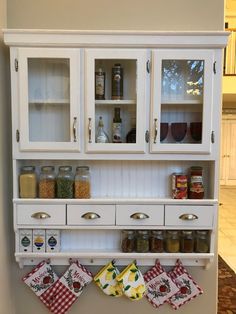 a kitchen with white cabinets and red checkered tea towels hanging on the door knobs