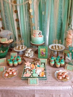 a table topped with lots of cupcakes and cakes