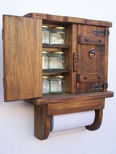 an old fashioned wooden medicine cabinet with glass jars in the door and drawers on it