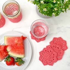 watermelon slices and strawberries on a plate next to a glass of water