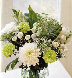 a vase filled with white and green flowers