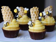 cupcakes decorated with bees and honeycombs on a plate