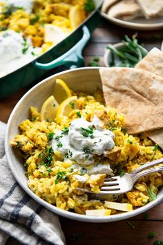 a bowl filled with rice and vegetables next to pita bread