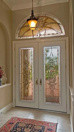 an entryway with two glass doors and a rug on the floor