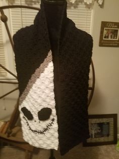 a crocheted scarf with a smiling face on it