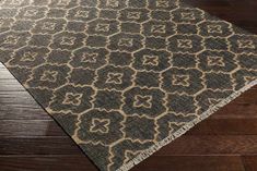 a brown and black rug on top of a wooden floor with wood floors in the background