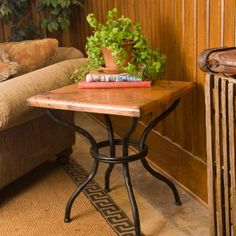 a small table with a plant on it next to a couch