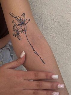 a woman's arm with a flower tattoo on the left side of her arm