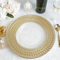 a white table topped with gold plates and flowers