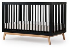 a black crib with white sheets on the bottom and wood legs, in front of a white background