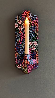 a candle that is lit on a wall