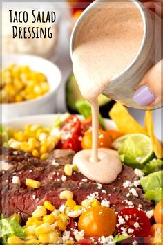 taco salad dressing being drizzled on top of steak with corn and tomatoes