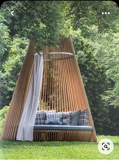 a wooden swing bed in the middle of some grass