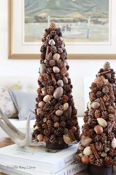 two pine cone christmas trees sitting on top of books