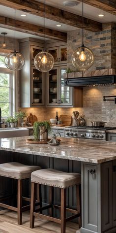 a kitchen with two stools in front of an island and lights hanging from the ceiling