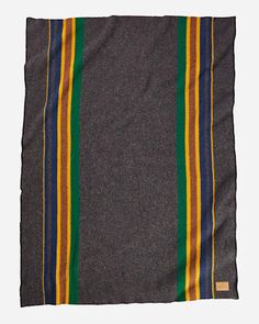 a gray blanket with multi - colored stripes on it's edges, folded in front of a white background