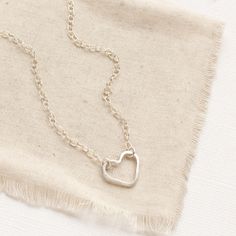 A simple, yet unique necklace to show your love. A simple forged silver heart hangs on silver chain. The heart is attached at two points, so it can change orientation from the side to right side up. Necklace measures 17" - 18 1/2" with lobster clasp and adjustable length chain closure. Small pearls frame the clasp and dangle down the back. Sterling silver. Your jewelry will arrive beautifully gift wrapped in a small box. Multiple items will be combined, unless separate boxes are requested. You will be able to complete this request during check out. If this is a gift being shipped directly to the recipient, you can use the gift box option during check out to include the gift message. If you do not use the gift option, there is no way for me to know these are gifts and your pieces will be wr Minimalist Adjustable Heart Necklace, Minimalist Adjustable Heart Pendant Necklace, Adjustable Open Heart Necklace With Adjustable Chain, Adjustable Open Heart Necklace, Simple Silver Heart Pendant Necklace, Adjustable Sterling Silver Heart Necklace For Everyday, Silver Heart Necklace, Hand Forged, Silver Hand Forged Heart Necklace, Nickel-free Minimalist Sterling Silver Heart Necklace