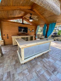 a covered outdoor kitchen with an entertainment center