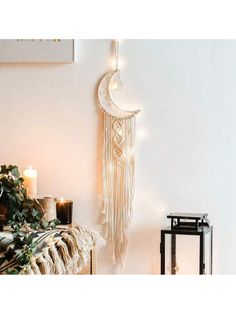 a white wall hanging next to a table with candles