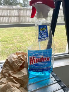 a bottle of windex is sitting on a window sill