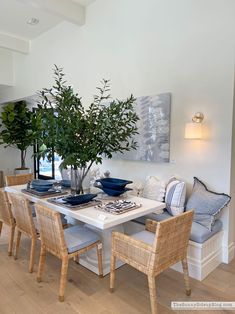 a dining room table with chairs and a potted plant on top of the table