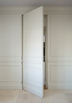 an open door in a white room with beige walls and flooring on either side