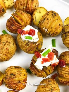 potatoes with cream cheese and green onions are on a white plate, ready to be eaten