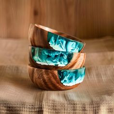 two wooden bracelets with blue swirl designs on them