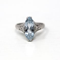 Beautiful vintage circa 1930s Art Deco era 14k white gold genuine aquamarine ring! This stunning ring features a marquise cut 2.8 carat blue genuine aquamarine gemstone, that is securely prong set. The setting features open metal designs on the gallery and unique nature inspired designs accented with milgrain. A gorgeous piece of fine vintage jewelry, featuring March's birthstone!  ERA - Circa 1930s - Art Deco METAL / MATERIAL - 14k white gold, genuine aquamarine (approx. 2.8 CT) MARKINGS / HIST Vintage Aquamarine Ring, Aquamarine Ring Vintage, 1930s Art, Logo Gifts, Unique Nature, Aquamarine Ring, Ring Art Deco, March Birthstone, Nature Inspired Design