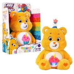 a yellow teddy bear with a birthday cupcake on its lap next to a box