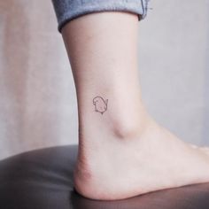 a small tattoo on the ankle of a woman's foot that has a bird drawn on it