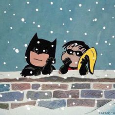 batman and catwoman are sitting on a brick wall in the snow, one is holding a banana