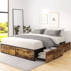 a bed sitting on top of a hard wood floor next to a white wall and window