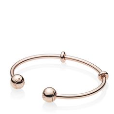 A sleek addition to your jewelry box, Pandora's 14K rose gold-plated Pandora Moments Open Bangle is minimally detailed with silicone stoppers that double as adornments. The polished style is plated with 14K rose gold for a warm finish. The logo-embossed end caps are easily removed to add charms — and are interchangeable to suit your mood. Classic Adjustable Rose Gold Bangle, Adjustable Modern Rose Gold Bangle, Pandora Logo, Open Bangle Bracelet, Pandora Rose, Polished Style, Bracelet Pandora, Open Bangle, Pandora Bracelets