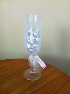 a clear glass filled with candy on top of a wooden table