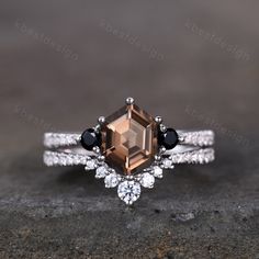 an engagement ring with a brown diamond and black diamonds on the sides, set in white gold