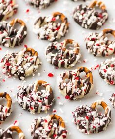 chocolate covered pretzels with white and red sprinkles on a baking sheet