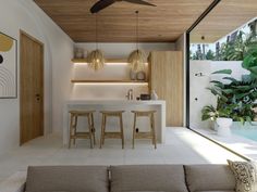 a living room filled with furniture next to a kitchen and dining area covered in plants