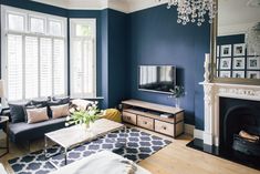 a living room filled with furniture and a flat screen tv on top of a wooden table