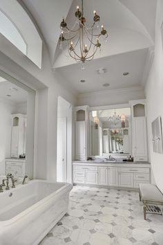 a large bathroom with a chandelier hanging from the ceiling and marble tile flooring