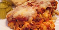 a white plate topped with lasagna and bread