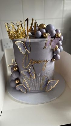 a cake decorated with purple and gold butterflies