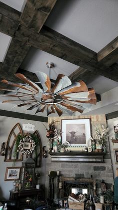 a living room filled with furniture and a fire place under a wooden ceiling fan over a fireplace