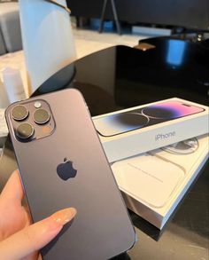 a person holding an iphone in their hand next to a box with the phone on it