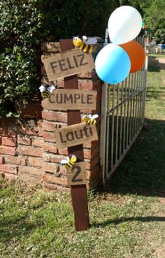 a sign that says feliz cumple lourt with balloons attached to it