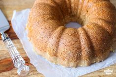 a bundt cake sitting on top of a piece of paper next to a knife