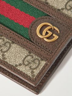 Gucci's 'Ophidia' wallet is inspired by accessories from the house's archive. It's made from coated-canvas printed with the iconic 'GG' monogram, which matches the burnished gold-tone hardware, and is centred by red and green webbing stripes. Designer Brown Rectangular Wallet, Rectangular Gucci Wallet For Travel, Gucci Brown Wallets With Interior Card Slots, Brown Gucci Wallets With Interior Card Slots, Gucci Bifold Wallet For Everyday Use, Gucci Travel Wallets With Card Slots, Gucci Wallets With Card Slots For Travel, Luxury Wallets With Engraved Logo For Everyday Use, Designer Brown Wallet As Gift