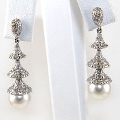 This Is A Fine South Sea Pearl & Diamond Dangle Earrings. They Are Made Of 100% Natural 14kt White Gold And Are In Brand New Condition. The Size Of The Pearls Are 8.5 Mm Each, They Have A Ctw Of .50ct And Weighs 7.0 Grams. The Fancy Diamonds Have A Clarity Of Si1 And G Color. This Beautiful Custom Piece Has Excellent Round Pearl Stones, Surrounded By Diamond Accents That Form A Loop Design. Samson Diamond 100% Authentic Natural Diamonds, Gemstones, And Gold. Never Lab Created/Synthetic/Fake Classic Silver Platinum Pearl Earrings, Anniversary White Gold Platinum Pearl Earrings, Diamond White Pearl Earrings With Pave Setting, White Platinum Dangle Diamond Earrings, Luxury White Pearl Earrings With Pave Setting, White Diamond Evening Earrings, Silver Platinum Pearl Earrings For Anniversary, Formal Fine Jewelry Pearl Earrings With Pave Setting, Silver Platinum Pearl Earrings For Wedding